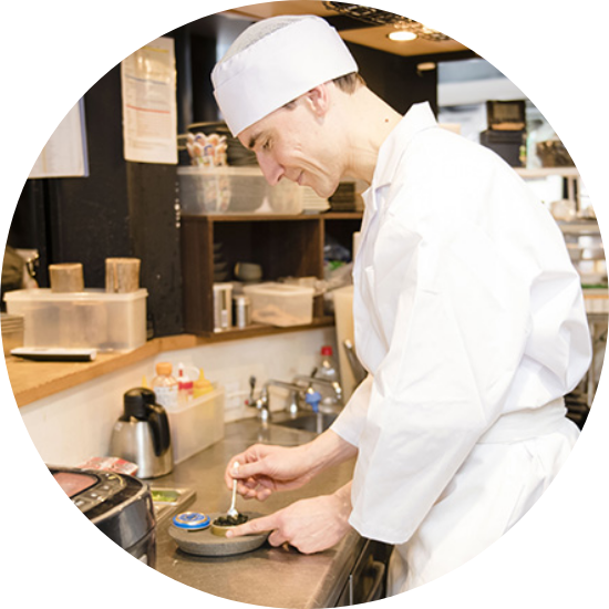 キッチンでお料理の盛付をするスタッフの写真