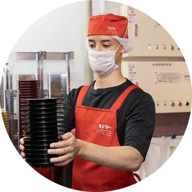 キッチンで洗ったお皿を運ぶスタッフの写真