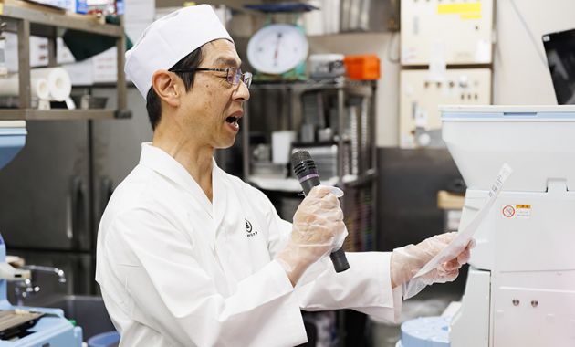 キッチンで注文を読み上げるスタッフの写真