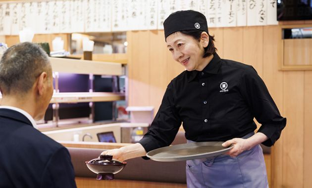 ホールでお客様にお料理を提供しているスタッフの写真