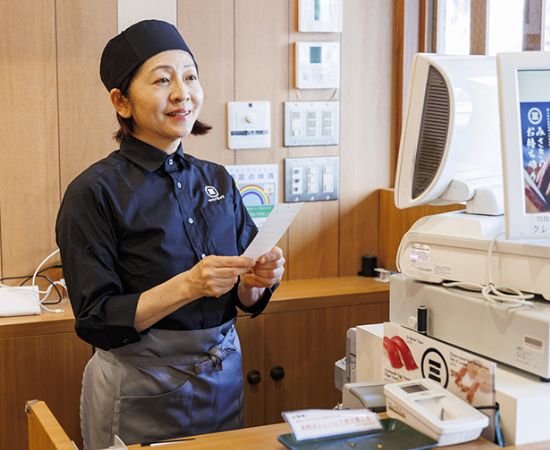 レジで伝票を見ながら会計をしているスタッフの写真