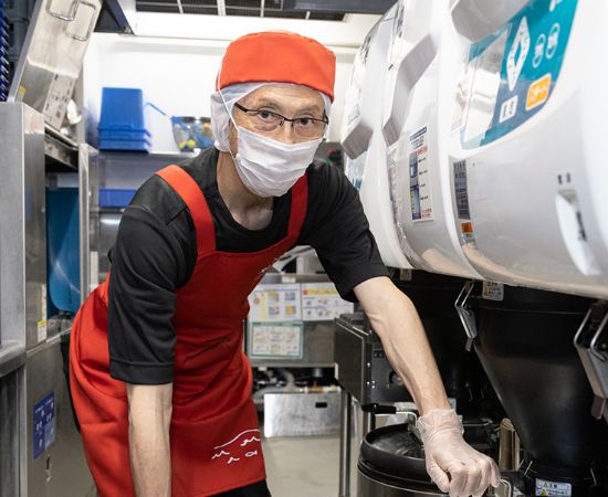 キッチンで炊きあがったご飯を確認しているスタッフの写真